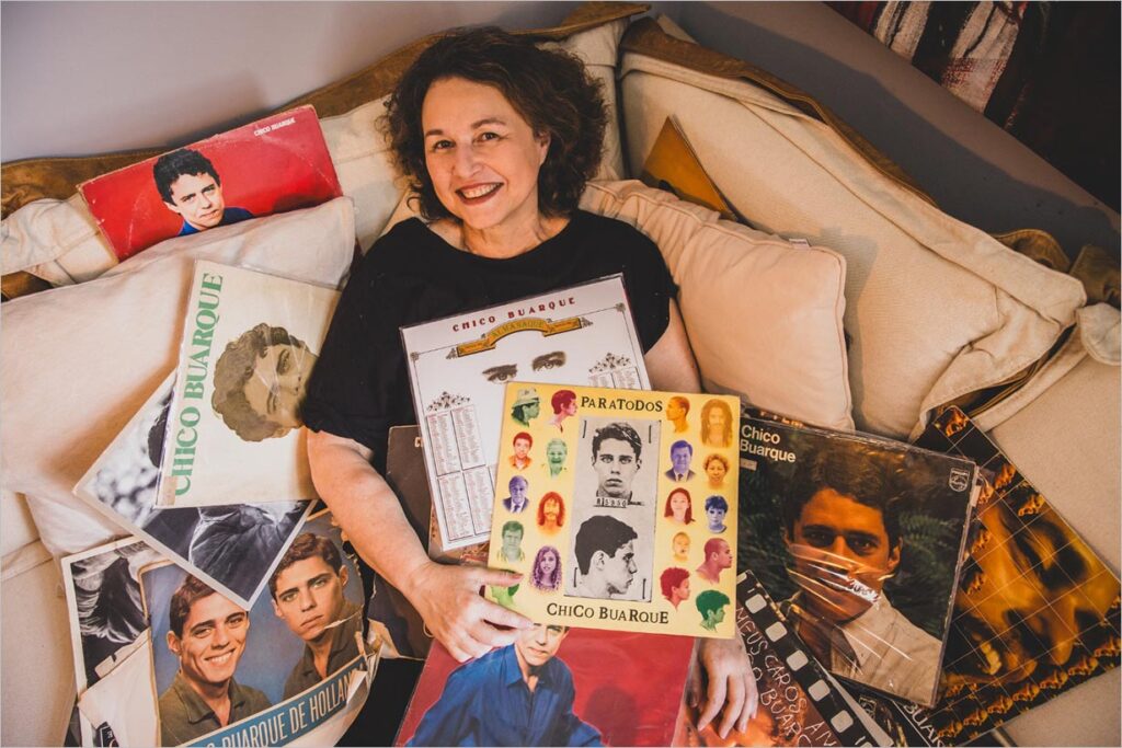 A foto mostra a atriz sentada em um sofá com diversos discos de Chico Buarque ao seu redor. Foto: Renato Mangolin