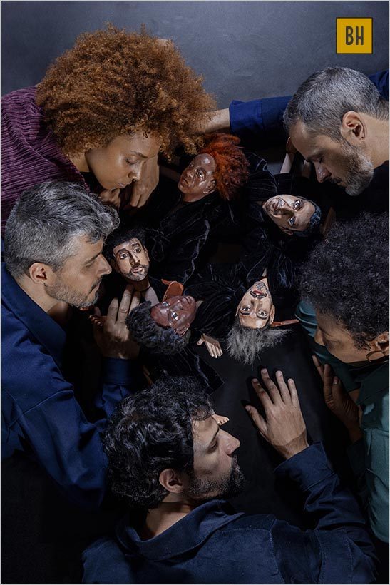 Duas atrizes e três atores deitados em torno de bonecos que os representam. Foto: Igor Cerqueira